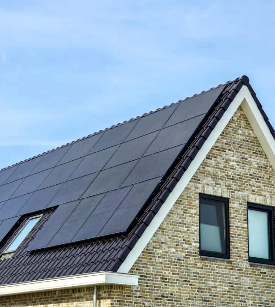 Residential roof with solar panels and black window frames.